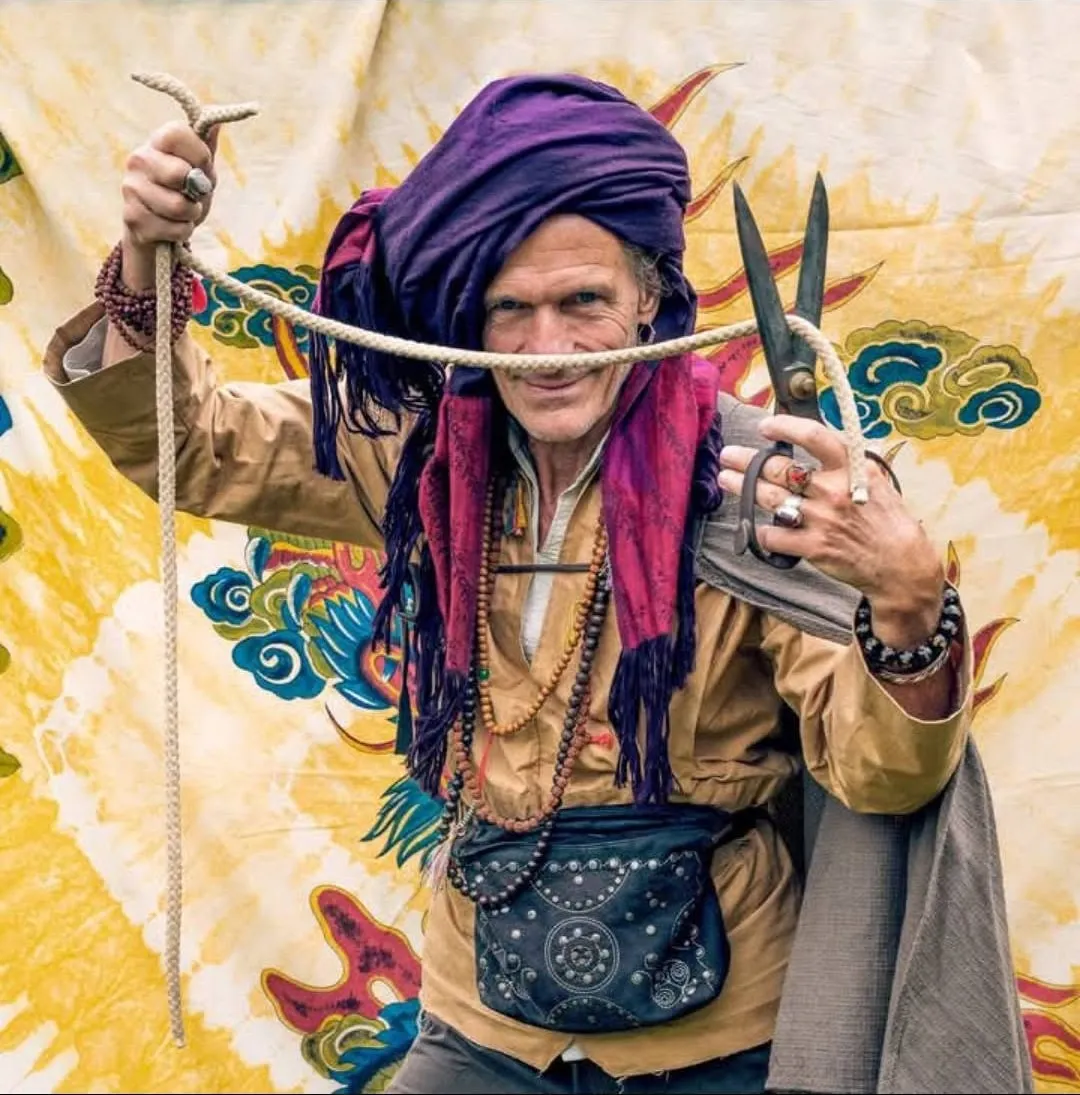 Sylvain en magicien, turban pourpre, cordes et grands ciseaux devant une toile dorée