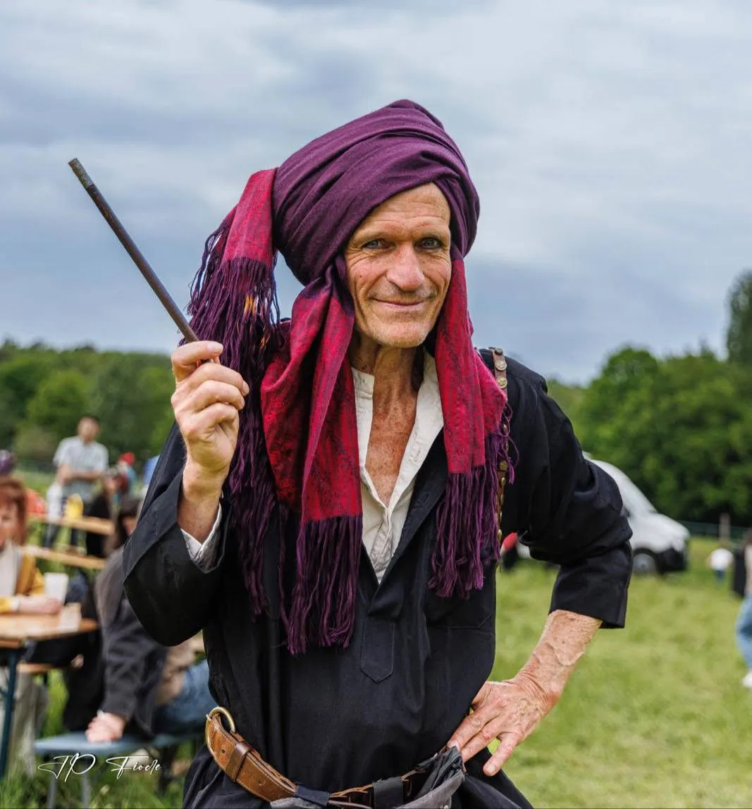 Sylvain en magicien médiéviste, turban pourpre et baguette, en fête médiévale