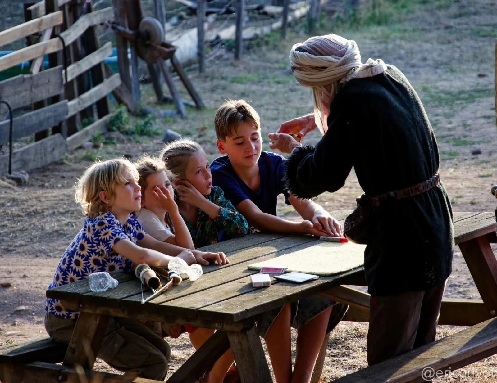 Sylvain fait un tour de cartes en petit comité pour quelques enfants attentifs, en plein air
